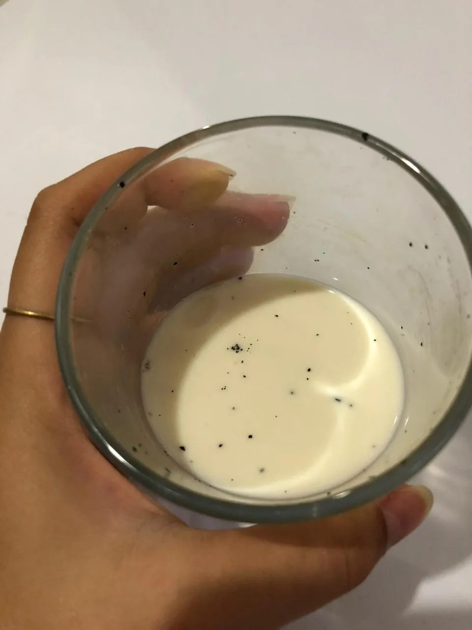 Vanilla seeds specked through a glass of milk